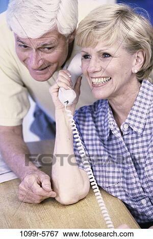 Senior couple listening in on a telephone View Large Photo Image Stock Photo - Senior couple listening in on a telephone. Fotosearch