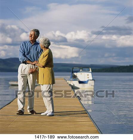 Stock Photo - Senior couple standing on a pier, Loch Lomond, Scotland. Fotosearch