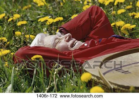 Stock Image - Senior man lying on grass. Fotosearch