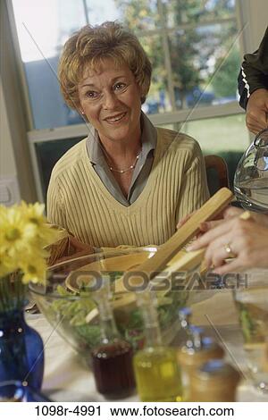 Stock Image - Senior woman at the breakfast table. Fotosearch