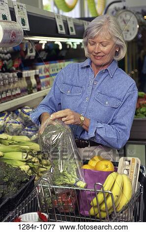 Stock Photo - Senior woman shopping in a grocery store. Fotosearch