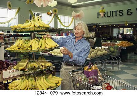 Senior woman shopping in a grocery store View Large Photo Image Stock Photo - Senior woman shopping in a grocery store. Fotosearch