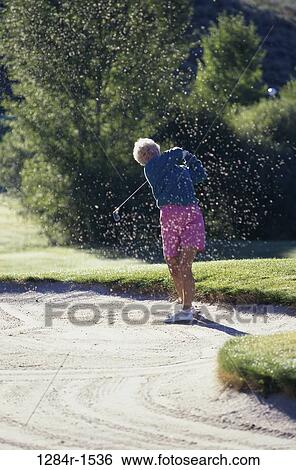 Senior woman swinging a golf club View Large Photo Image Stock Photograph - Senior woman swinging a golf club. Fotosearch