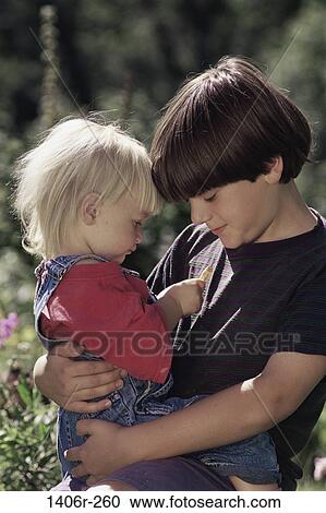 Stock Image - Side profile of a boy carrying a girl. Fotosearch