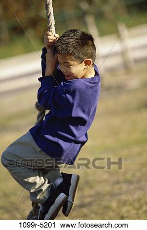 Side profile of a boy hanging from a jungle gym View Large Photo Image Stock Image - Side profile of a boy hanging from a jungle gym. Fotosearch