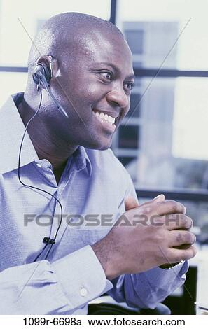 Stock Image - Side profile of a customer service representative smiling. Fotosearch