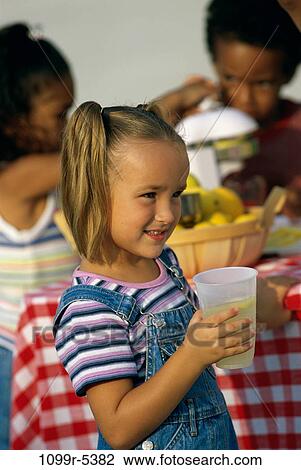 Side profile of a girl holding a glass of lemonade View Large Photo Image Stock Image - Side profile of a girl holding a glass of lemonade. Fotosearch