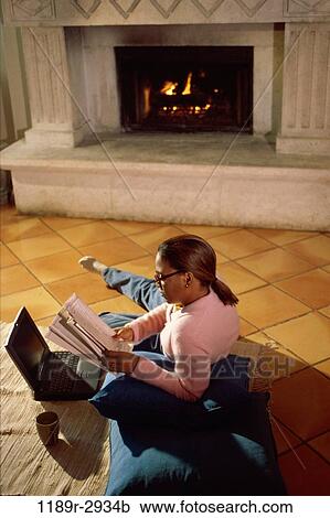 Side profile of a mid adult woman sitting on the floor reading a book View Large Photo Image Stock Image - Side profile of a mid adult woman sitting on the floor reading a book. Fotosearch