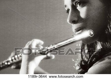 Side profile of a teenage girl playing the flute View Large Photo Image Picture - Side profile of a teenage girl playing the flute. Fotosearch