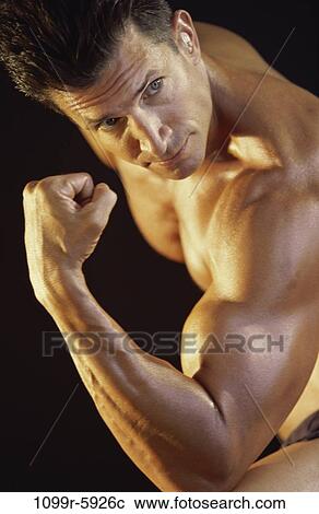 Side profile of a young man flexing his biceps View Large Photo Image Stock Image - Side profile of a young man flexing his biceps. Fotosearch