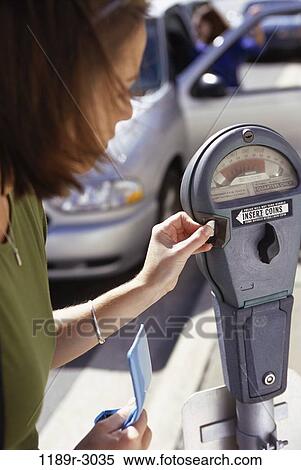 Side profile of a young woman feeding an expired parking meter View Large Photo Image Stock Photography - Side profile of a young woman feeding an expired parking meter. Fotosearch
