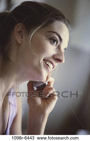 Side profile of a young woman talking on a mobile phone View Large Photo Image Stock Image - Side profile of a young woman talking on a mobile phone. Fotosearch