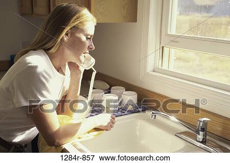Side profile of a young woman talking on a telephone View Large Photo Image Stock Photo - Side profile of a young woman talking on a telephone. Fotosearch