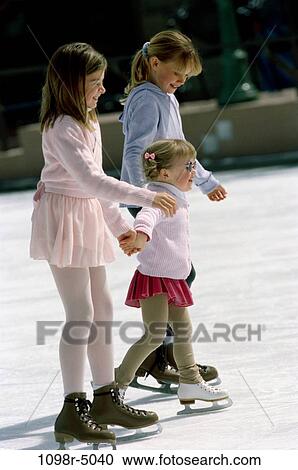 Stock Image - Side profile of three children ice skating. Fotosearch