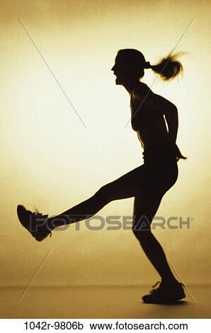 Silhouette of a young woman exercising View Large Photo Image Stock Image - Silhouette of a young woman exercising. Fotosearch