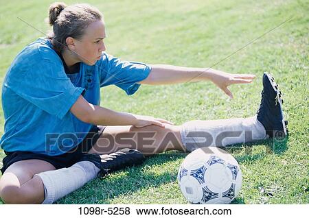 Stock Photo - Teenage girl stretching on a lawn. Fotosearch