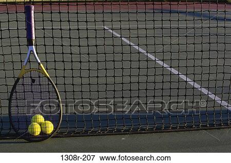 Stock Photo - Tennis balls and a tennis racket against a net. Fotosearch