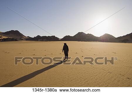 Tuareg man walking in a desert, Tadrart Acacus, Fezzan, Libya View Large Photo Image Stock Image - Tuareg man walking in a desert, Tadrart Acacus, Fezzan, Libya. Fotosearch