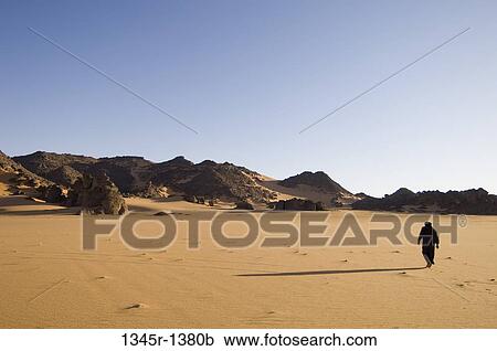 Tuareg man walking in a desert, Tadrart Acacus, Fezzan, Libya View Large Photo Image Stock Image - Tuareg man walking in a desert, Tadrart Acacus, Fezzan, Libya. Fotosearch