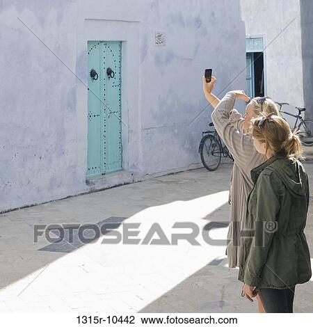 Tunisia, Kairouan, mother and daughter taking picture with cell phone View Large Photo Image Stock Image - Tunisia, Kairouan, mother and daughter taking picture with cell phone. Fotosearch