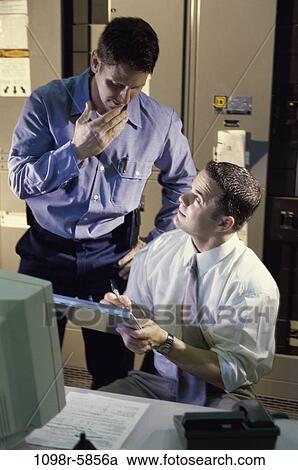 Stock Image - Two businessmen checking inventory. Fotosearch
