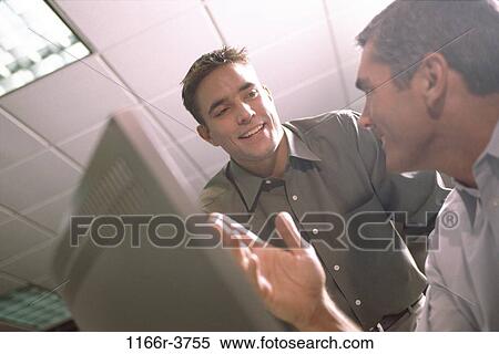 Stock Photography - Two businessmen in an office. Fotosearch
