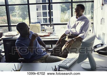 Two businessmen talking in an office View Large Photo Image Stock Image - Two businessmen talking in an office. Fotosearch