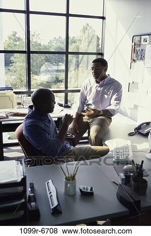 Stock Photo - Two businessmen talking in an office. Fotosearch