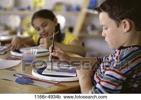Stock Image - Two children painting with paintbrushes. Fotosearch