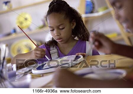 Stock Image - Two children painting with paintbrushes. Fotosearch