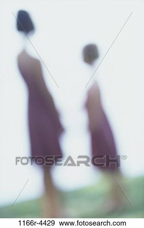 Stock Photo - Two girls standing on a lawn. Fotosearch