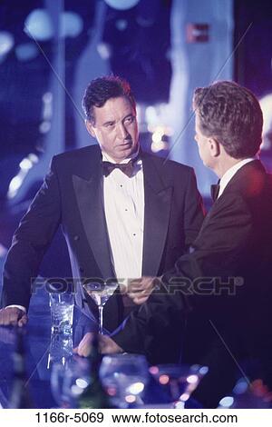 Two men standing at a bar View Large Photo Image Stock Photo - Two men standing at a bar. Fotosearch