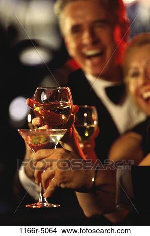 Two people toasting at a bar View Large Photo Image Picture - Two people toasting at a bar. Fotosearch