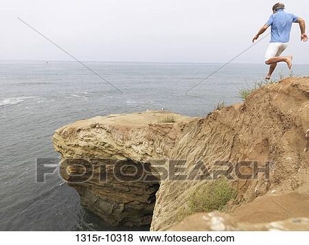 USA, California, San Diego, Man running down sandy slope towards ocean landing View Large Photo Image Stock Photo - USA, California, San Diego, Man running down sandy slope towards ocean landing. Fotosearch