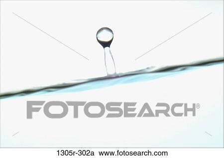 Stock Image - Water drop rising on the surface of water. Fotosearch