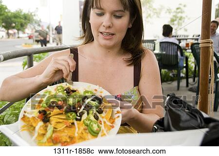 Woman eating food in a restaurant View Large Photo Image Stock Image - Woman eating food in a restaurant. Fotosearch