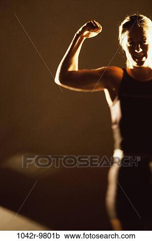 Stock Image - Woman flexing her biceps. Fotosearch