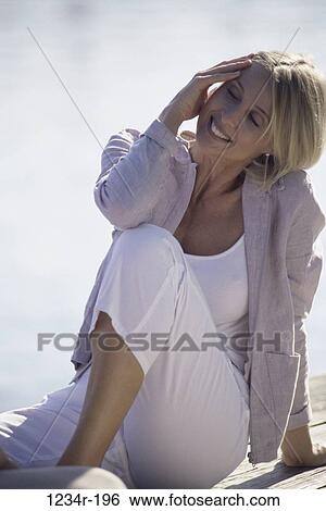 Woman sitting at the beach View Large Photo Image Stock Photograph - Woman sitting at the beach. Fotosearch