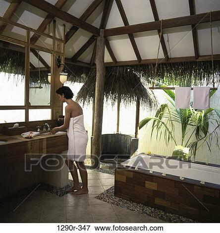 Woman standing at a sink wrapped in a towel View Large Photo Image Stock Photo - Woman standing at a sink wrapped in a towel. Fotosearch
