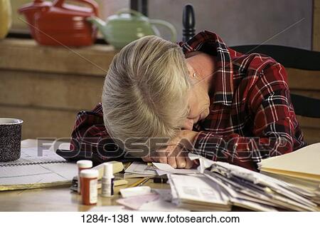 Woman with her head down on a table View Large Photo Image Stock Image - Woman with her head down on a table. Fotosearch