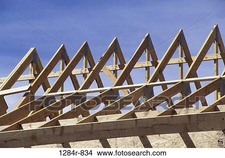 Picture - Wooden framework of a roof of a house under construction. Fotosearch