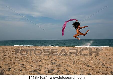 Picture - Young Brunette Woman at the beach enjoying herself. Fotosearch