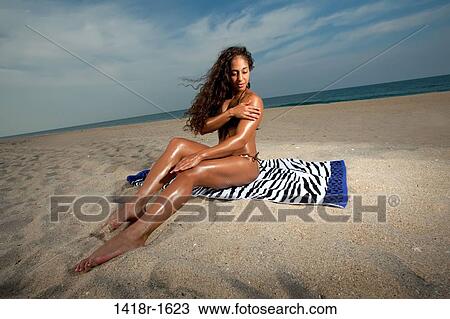 Stock Image - Young Brunette Woman at the beach enjoying herself. Fotosearch