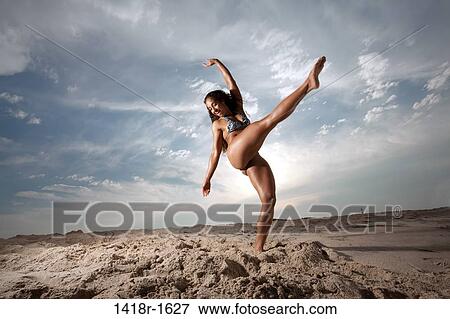 Stock Photo - Young Brunette Woman at the beach enjoying herself. Fotosearch