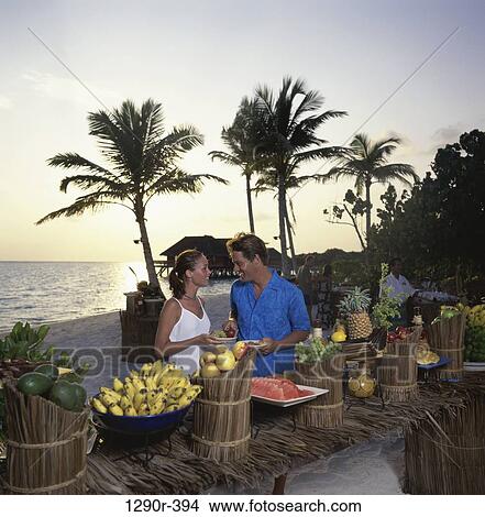 Young couple at a buffet on the beach, Maldives View Large Photo Image Picture - Young couple at a buffet on the beach, Maldives. Fotosearch