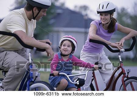 Stock Image - Young couple cycling with their daughter. Fotosearch