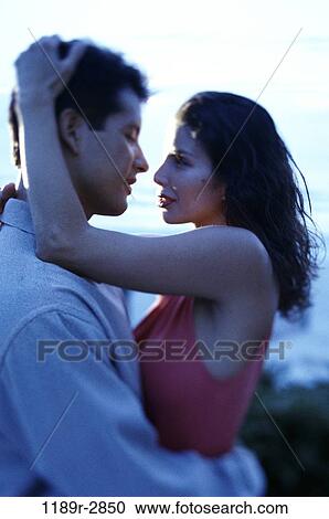 Stock Image - Young couple holding each other. Fotosearch