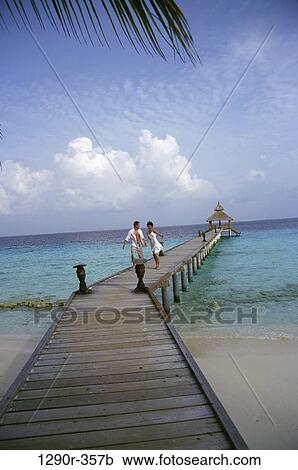 Young couple walking on a pier, Maldives View Large Photo Image Stock Image - Young couple walking on a pier, Maldives. Fotosearch