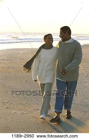 Young couple walking on the beach View Large Photo Image Stock Image - Young couple walking on the beach. Fotosearch