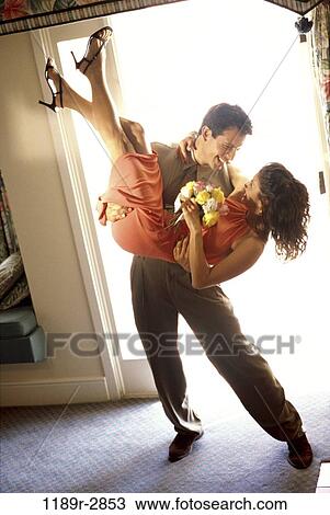 Stock Image - Young man carrying a young woman. Fotosearch